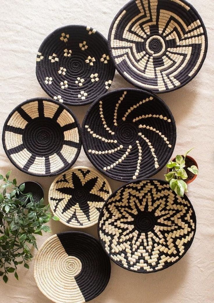 woven baskets are hanging on the wall next to a potted plant and some plants