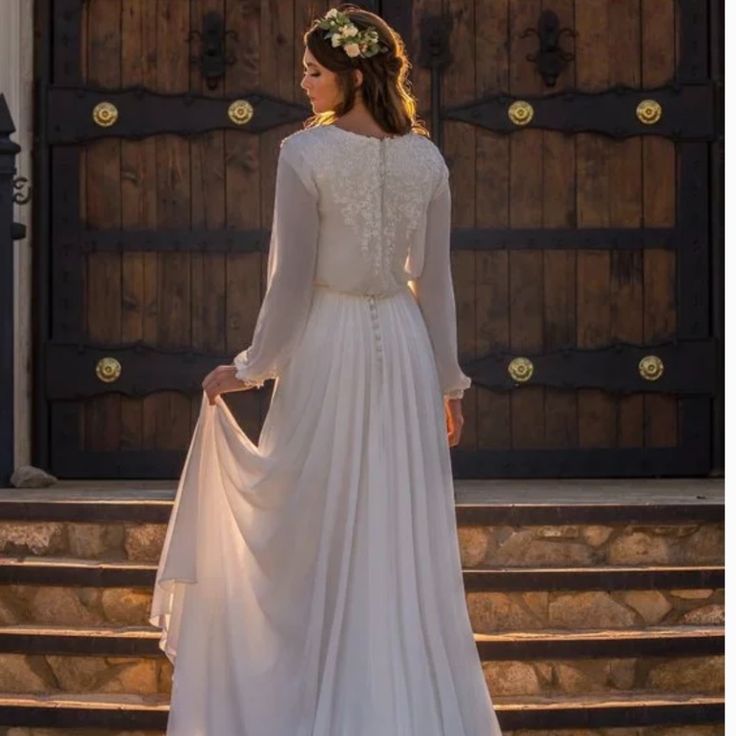 a woman in a wedding dress standing on steps