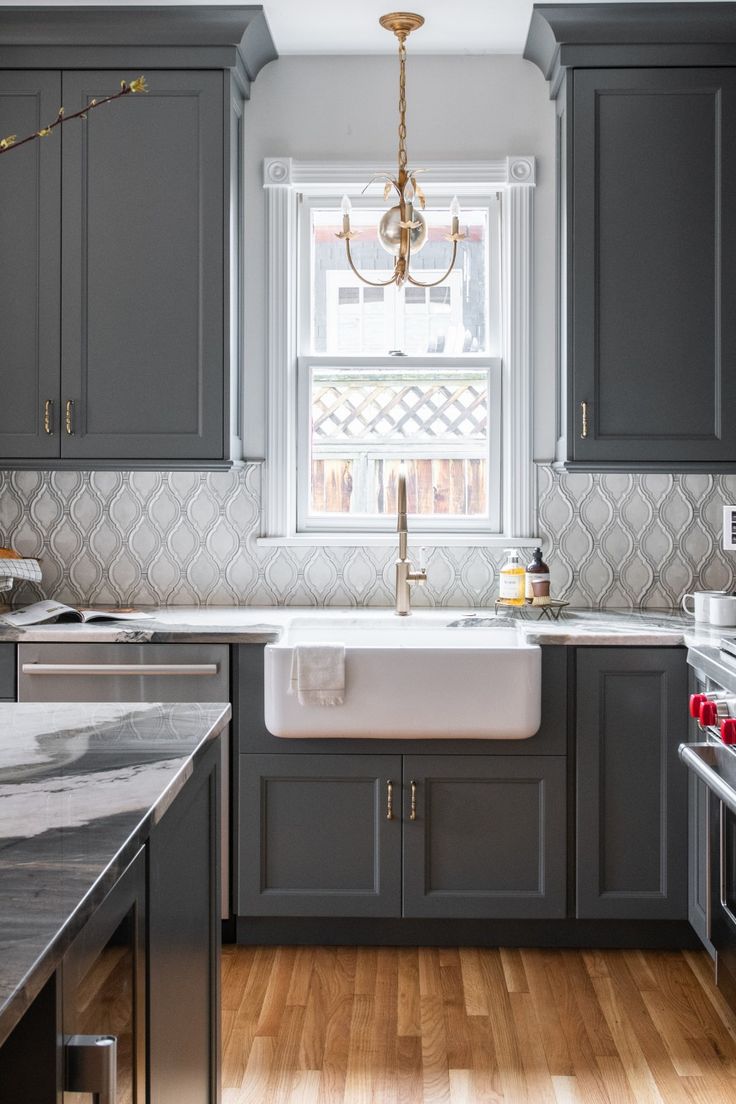 a kitchen with gray cabinets and wood floors