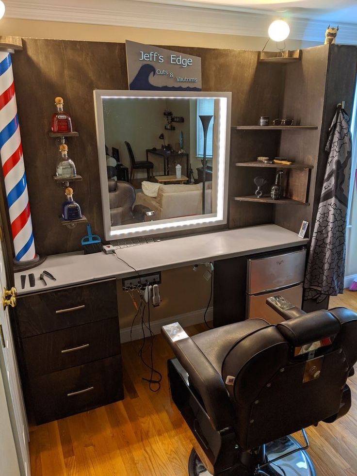 a barber chair sitting in front of a mirror on top of a wooden floor next to a desk