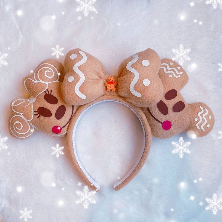 a close up of a headband with gingerbreads on it and snowflakes in the background