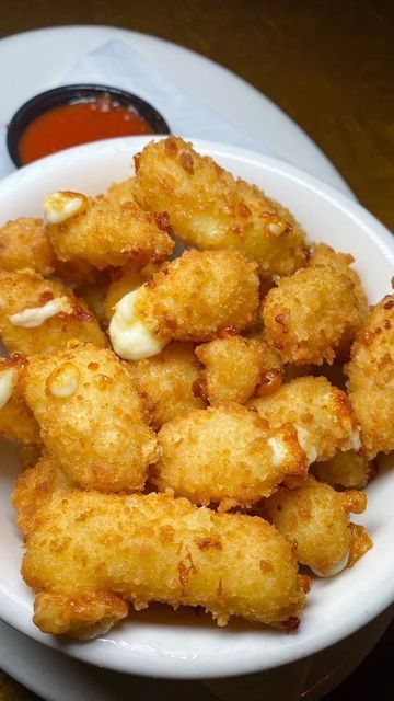 fried food on a white plate with dipping sauce