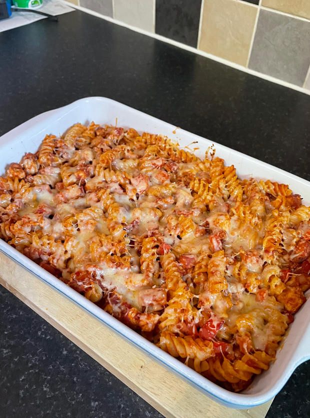 a large casserole dish filled with pasta and sauce on top of a counter