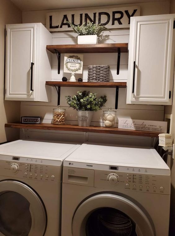 a washer and dryer in a laundry room with open shelving on the wall