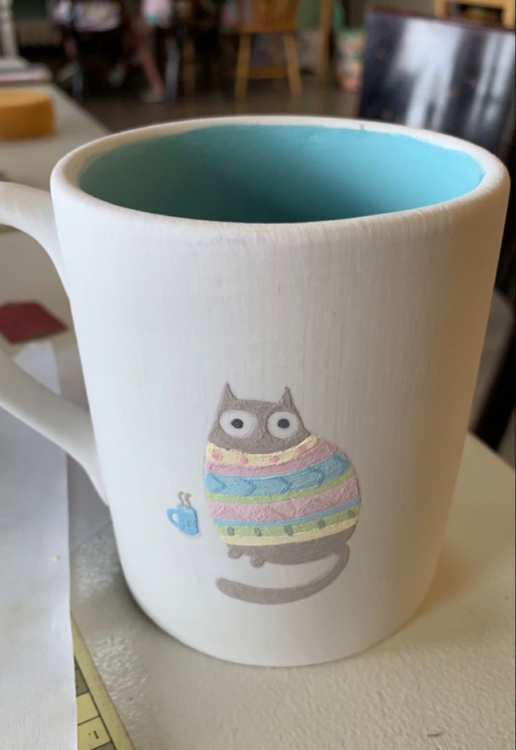 a coffee cup with an owl painted on it