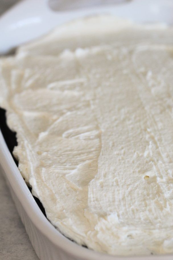 a pan filled with white frosting sitting on top of a counter