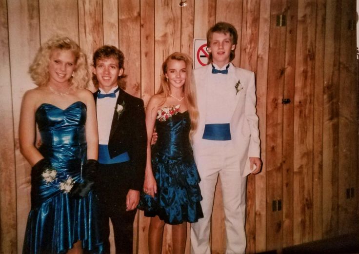 three young people in formal wear standing next to each other near a wooden paneled wall