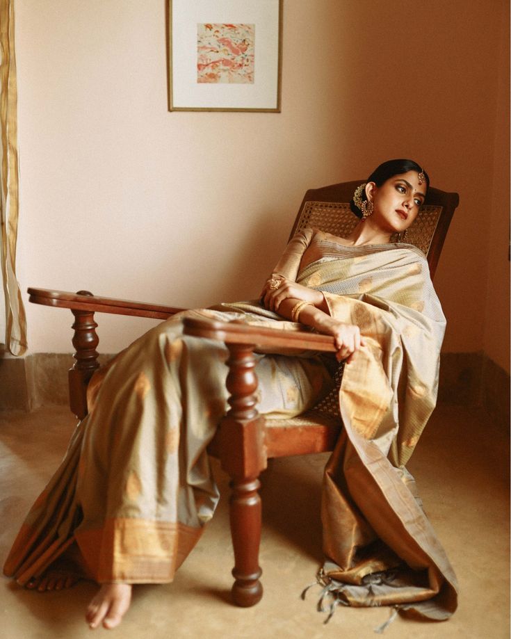 a woman sitting in a chair wearing a sari