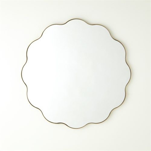 a mirror that is on the wall in front of a white wall with a gold frame