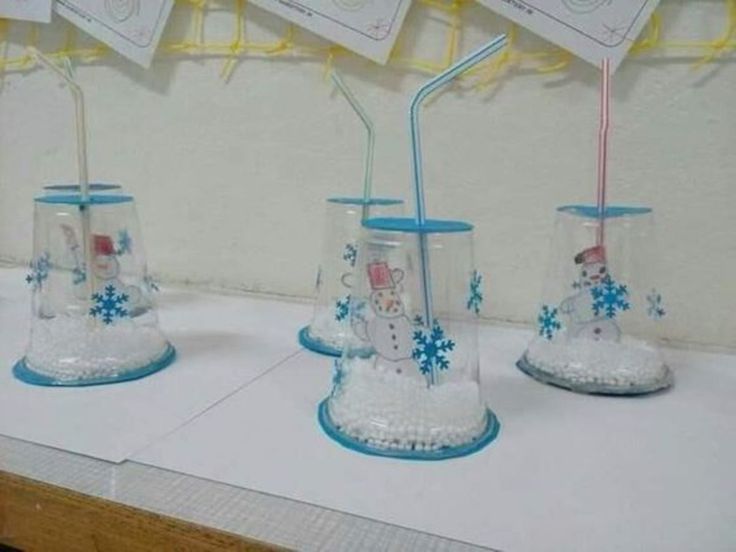 three glass cups with straws and snowmen on them, sitting on a table