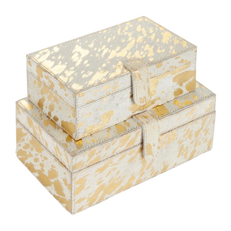 two white and gold boxes sitting side by side on top of each other with handles