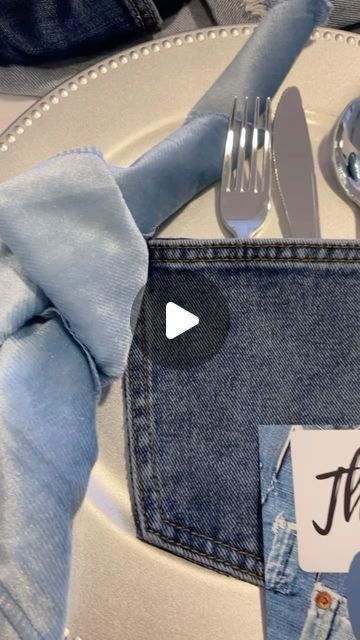 a table setting with silverware, napkins and blue denim pocketed jeans on it