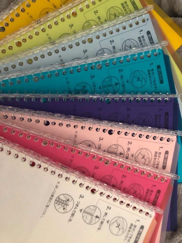 several different colored notebooks lined up on top of each other with numbers in them