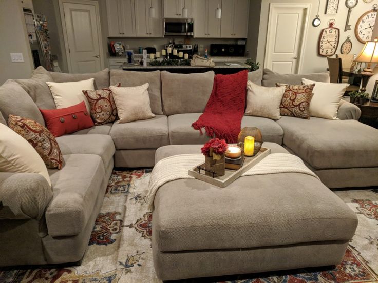 a living room filled with lots of furniture and pillows on top of a carpeted floor