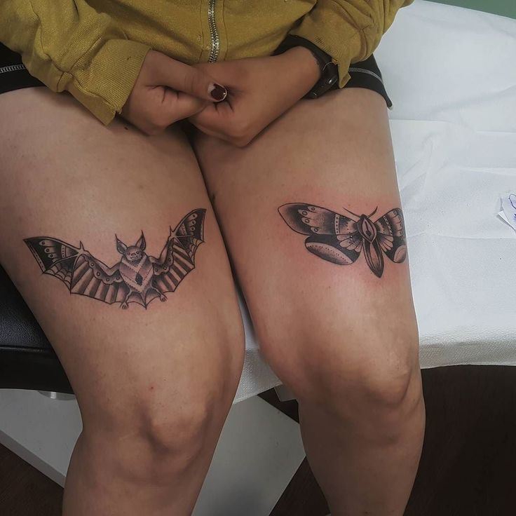 two women with tattoos on their legs sitting next to each other, one has a butterfly tattoo on her thigh