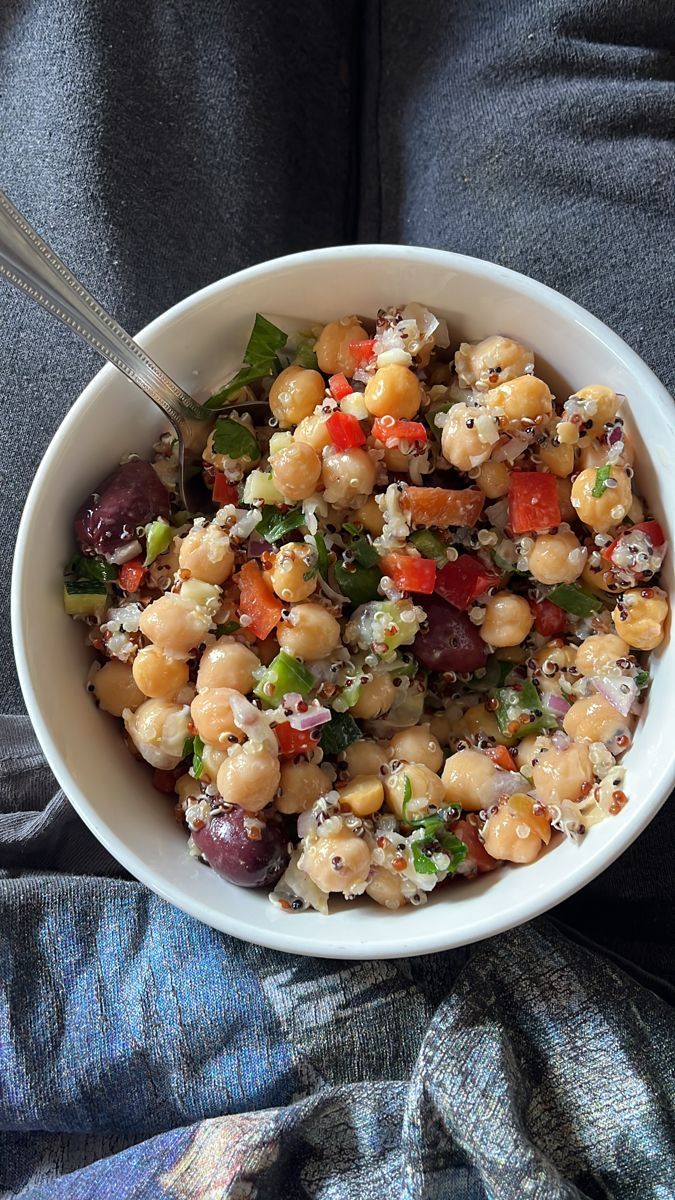 a white bowl filled with chickpeas and vegetables