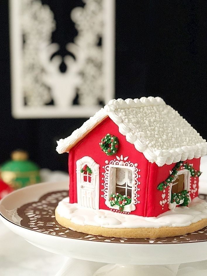 a decorated gingerbread house on a plate