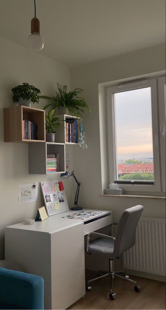 an office with a desk, chair and bookcase in front of a window overlooking the city