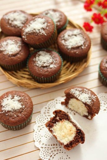 chocolate cupcakes with powdered sugar on top and one cut in half next to it