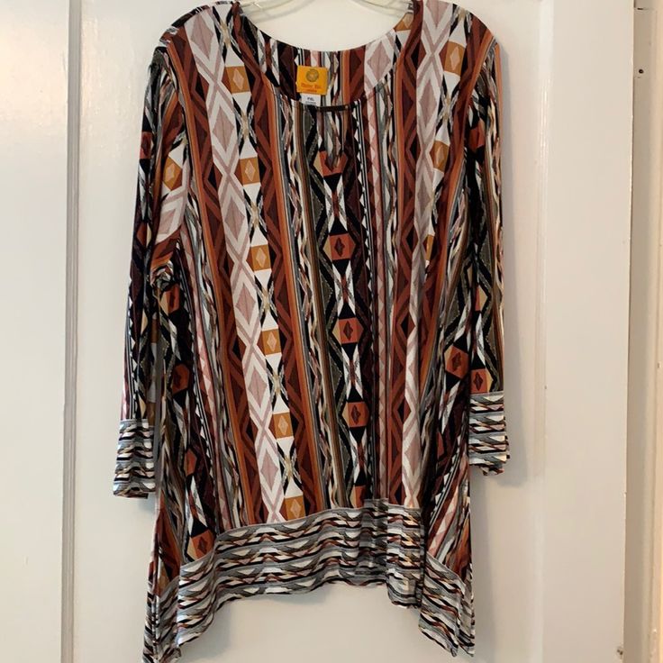 Tribal Print In Earth Tones Of Browns, Bronze, Cinnamon,And Black With A Keyhole Neckline Decorated With A Bronze Bar. Sleeves Are 3/4 And Shark Bite Bottom. Perfect For Fall. New Without Tags Multicolor 3/4 Sleeve Tops For Fall, Fall Multicolor Long Sleeve Tunic, Casual Multicolor Tunic For Fall, Multicolor Fitted Long Sleeve Tunic, Fitted Multicolor Long Sleeve Tunic, Patterned 3/4 Sleeve Tops For Fall, Beige Long Sleeve Fall Tunic, Shark Bites, Keyhole Neckline