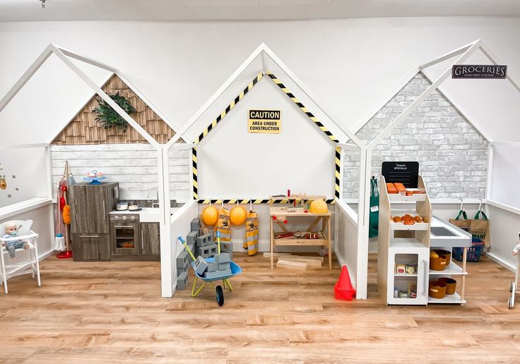 the children's play room has white walls and wooden floors