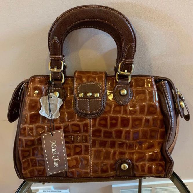 Nwt Madi Claire Brown Leather Satchel Handbag Brown Genuine Leather Brand New With Tags 2 Side Compartments For Easy Organization With Hook For Keys Middle Compartment With Top Zip Features Pockets, Pen/Lipstick Holders, Inside Secure Zip Gold Colored Hardware Bottom Feet Comes With Detachable Crossbody Strap More Madi Claire Nwt In My Closet! Hi! Welcome To My Poshmark Closet, Thanks For Stopping By! Be Sure To Check Out My Other Listings For Some Great Finds! Brown Faux Leather Satchel With Top Handle, Brown Faux Leather Satchel With Top Carry Handle, Vintage Brown Satchel With Brass Hardware, Brown Calf Leather Satchel With Gold-tone Hardware, High-end Brown Satchel With Gold-tone Hardware, Brown Faux Leather Satchel With Gold-tone Hardware, Brown Faux Leather Shoulder Bag With Gold-tone Hardware, Brown Satchel Bag With Gold-tone Hardware, Distressed Brown Leather-lined Satchel Bag