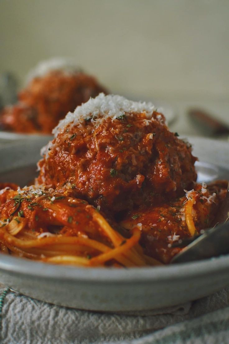 spaghetti and meatballs are served in a bowl