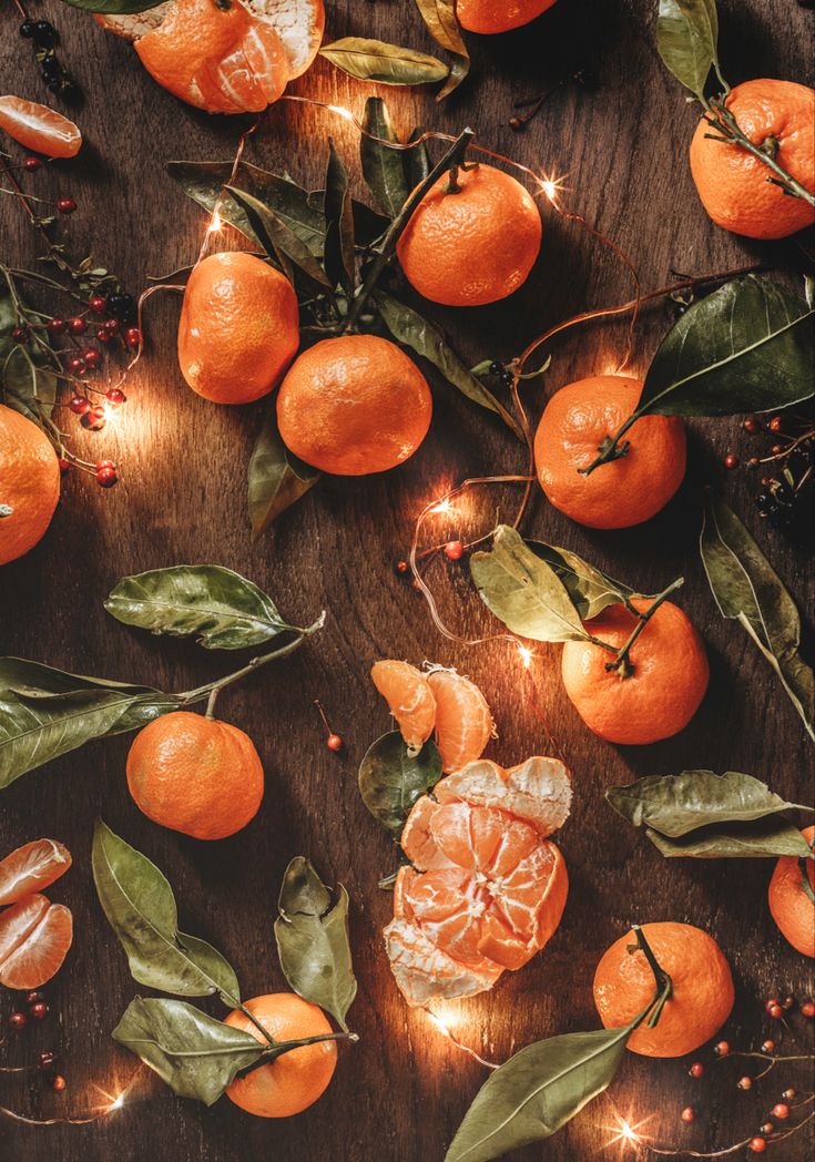 several oranges with leaves and lights on them