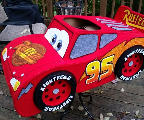 a red toy car sitting on top of a wooden deck