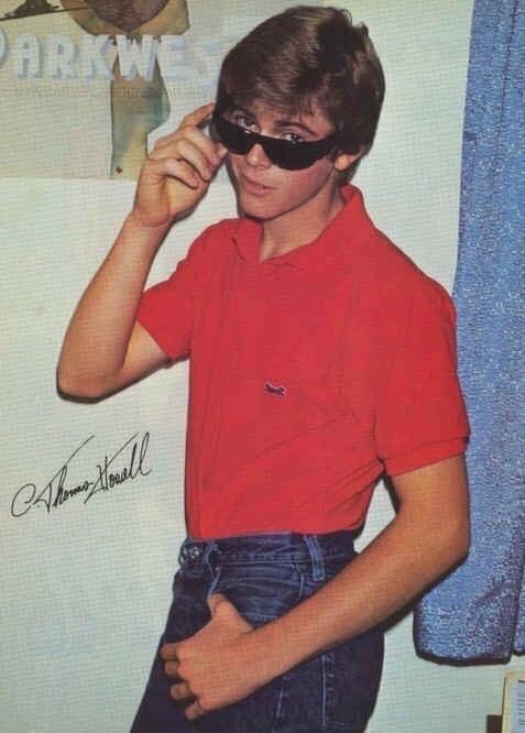 a young man wearing sunglasses is standing in front of a wall