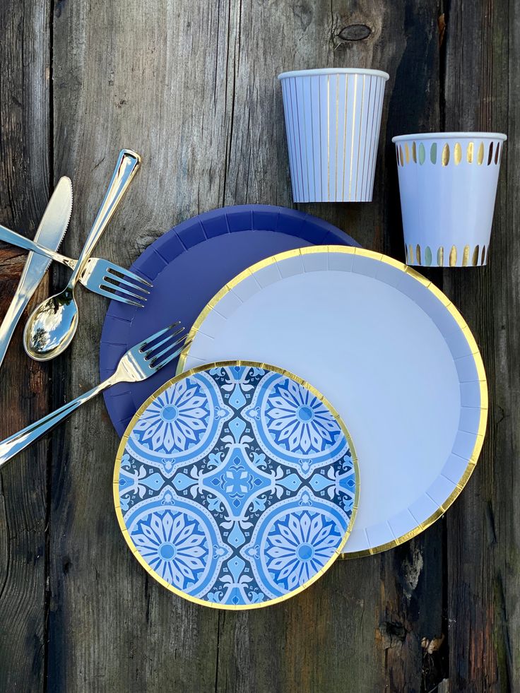 blue and white plates, cups and utensils on wooden table