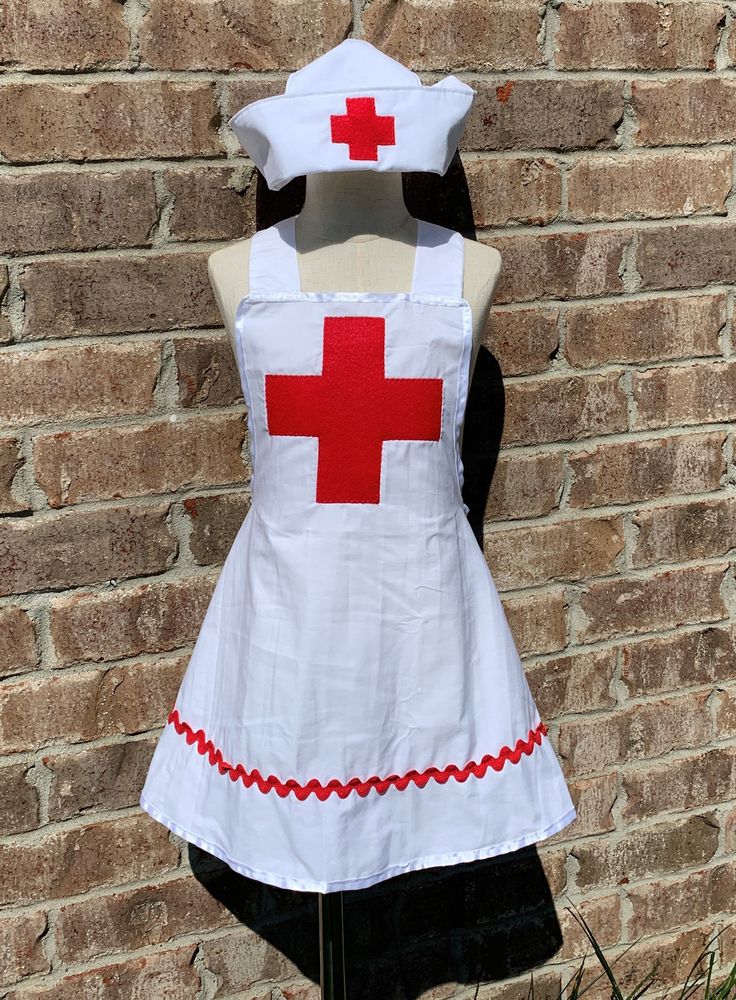 a dress made to look like a nurse's uniform is displayed in front of a brick wall