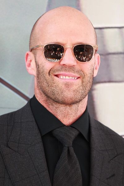 a bald man wearing sunglasses and a suit