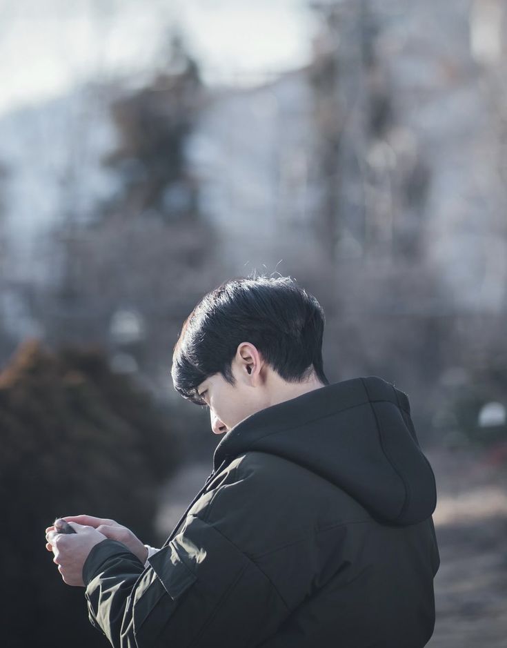 a man looking at his cell phone in the park