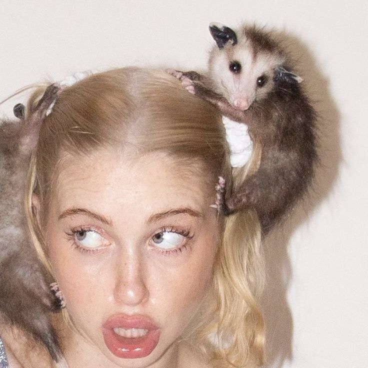 a woman with two possles on her head and another animal sitting on top of her head