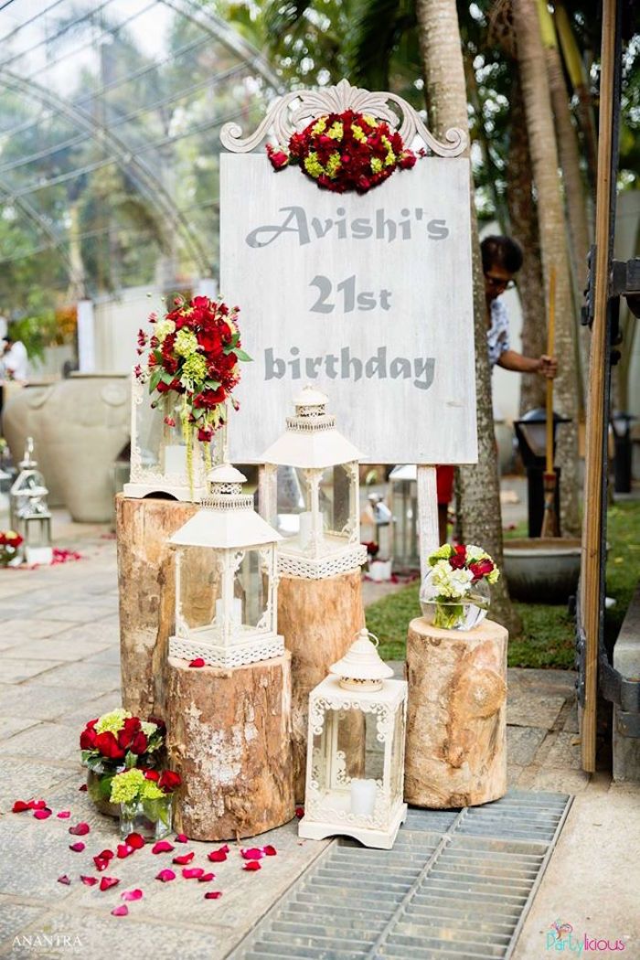 a sign that is on the side of a tree stump with flowers in vases