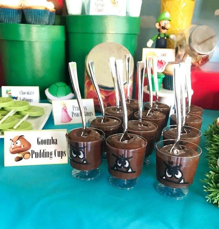 there are chocolate cups with spoons in them on the table at a party or event