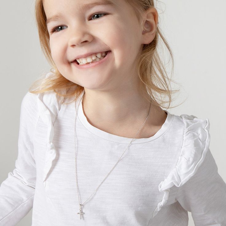 Looking for a timeless cross for an adorable little one? This understated yet elegant tiny cross necklace rests on its own matching chain, and is entirely crafted of sterling silver making it suitable for those with sensitive skin. This tiny cross comes neatly packaged in its own little gift box for your convenience. Age Group: Elegant for Babies, Infants, Young Girls & Preteens (0-12 years); Safe for Sensitive Skin Material: 925 Sterling Silver Cross Size: 9mm W x 12mm H polished plain cross Me Tiny Cross Necklace, Girls Necklace, Tiny Cross, Girls Necklaces, Sterling Silver Cross, Toddler Kids, Religious Jewelry, Silver Cross, Infants