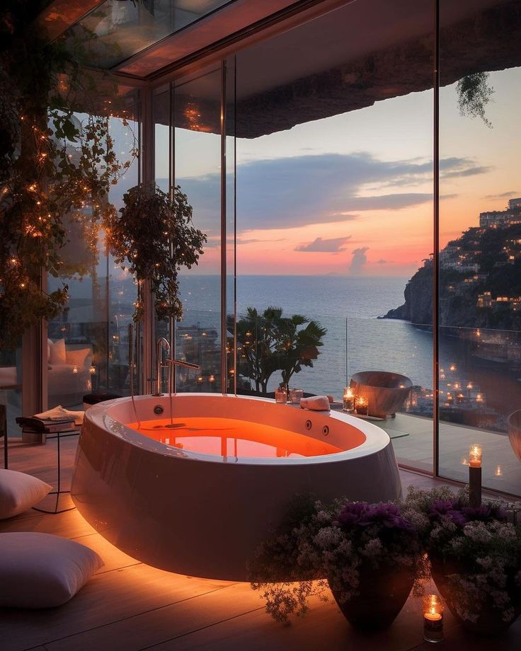 a large bath tub sitting on top of a wooden floor next to a lush green hillside