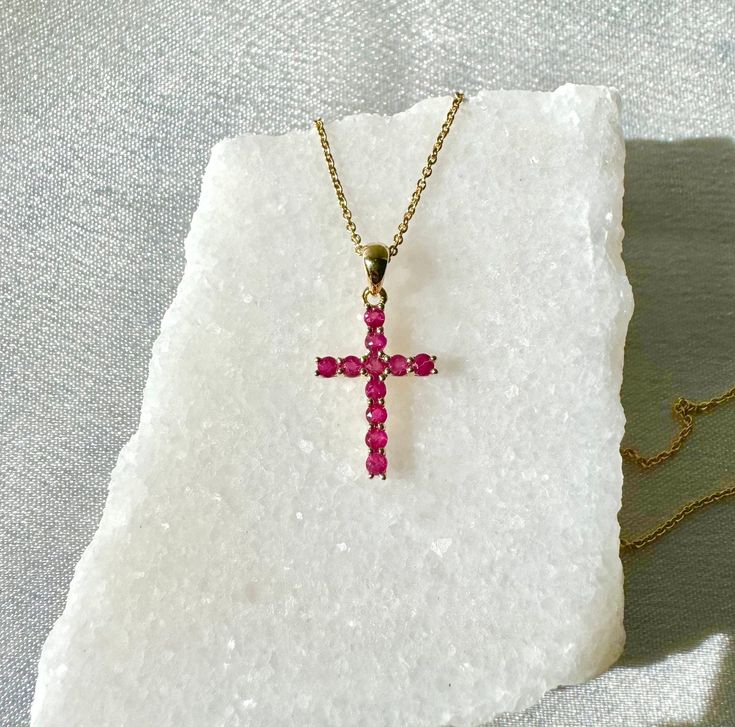 "A timeless and classic design, symbolizing love, commitment and wealth. Perfect for everyday wear or dressed up for special occasions. Rubies are said to symbolize the sun, while its glowing hue suggests an inextinguishable flame within the stone. Add a pop of color with our Genuine Ruby Round Cut Cross Pendant, available in 14k solid white gold and 14k solid yellow gold. 14k solid white gold and 14k solid yellow gold chain available for additional purchase to match your beautiful pendant.  Item Specifications: Materials: 14k Solid Gold  Gemstone: Natural Rubies Pendant Diameter 20 mm x 10.7 mm Total Gold Weight: 0.61 ct. Total Rubies Weight: 0.31 ct.  Necklace: Adjustable 16 and 18 inches with a lobster clasp Chain Weight: 0.6 mm 1.35 grams  ★  Each order will be beautifully packaged in Gemstone Cross Pendant Jewelry Gift, Spiritual Yellow Gold Jewelry With Gemstones, Spiritual 14k Gold Cross Jewelry, Symbolic Gemstone Jewelry For Formal Occasions, Spiritual Round Jewelry For Valentine's Day, Polished Ruby Jewelry Gift, Gift Ruby Jewelry With Polished Finish, Polished Ruby Jewelry For Gifts, Ruby Jewelry With Polished Finish As A Gift