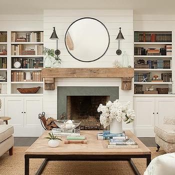 a living room filled with furniture and a fire place in front of a bookshelf