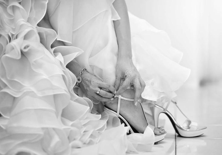 black and white photo of woman in high heeled shoes with ruffled skirt on the floor