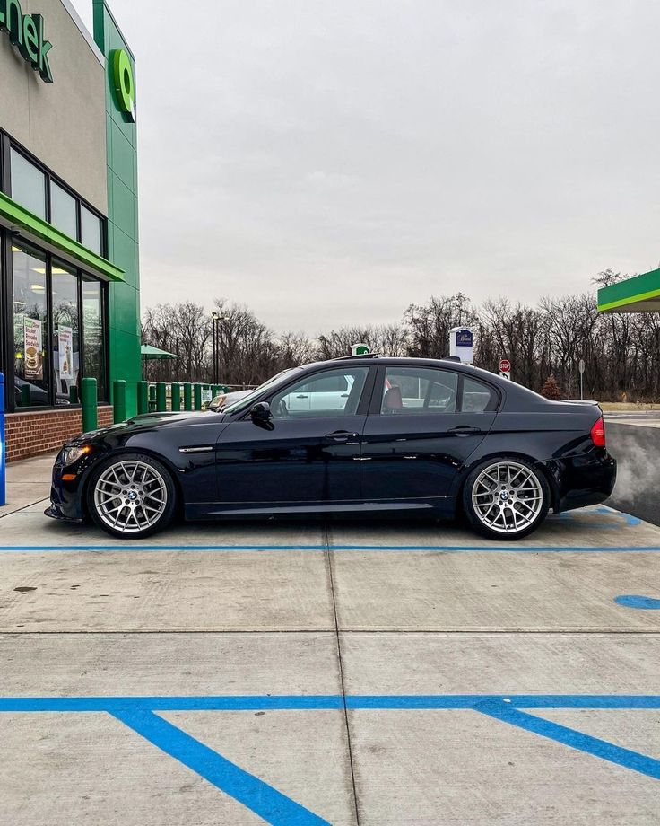 a black car parked in front of a gas station