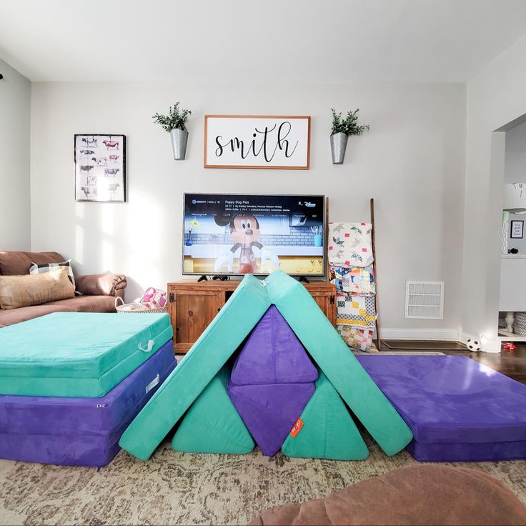 the living room is decorated in purple, green and blue foams that are stacked on top of each other