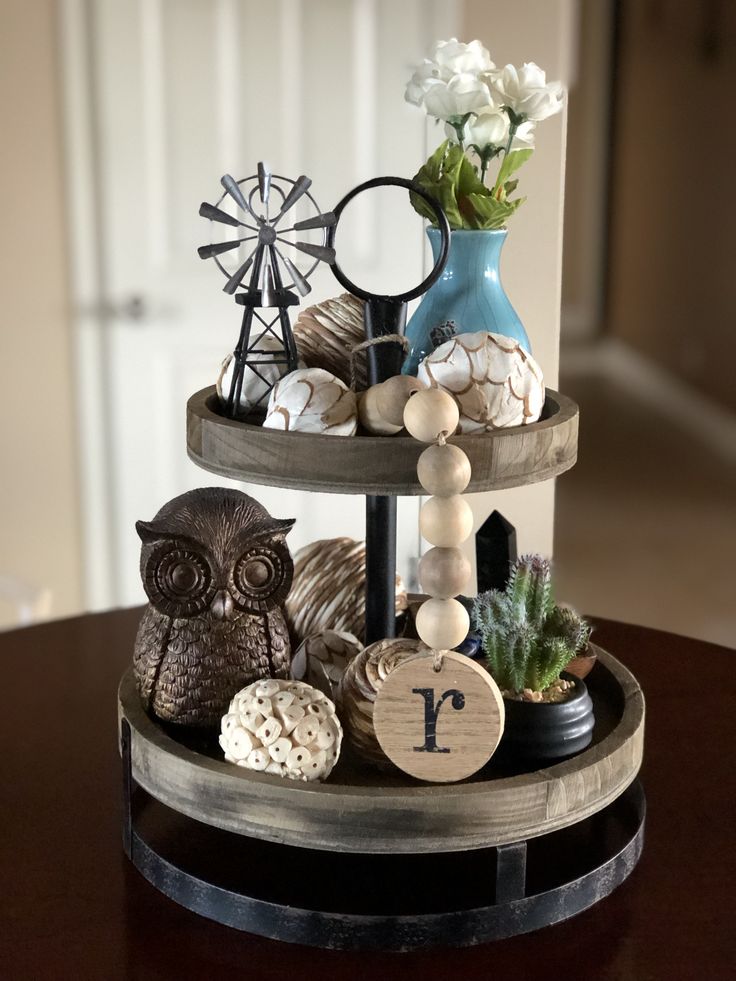 two tiered trays holding decorative items on a table