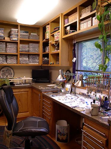 a home office with lots of clutter on the desk and shelves full of books