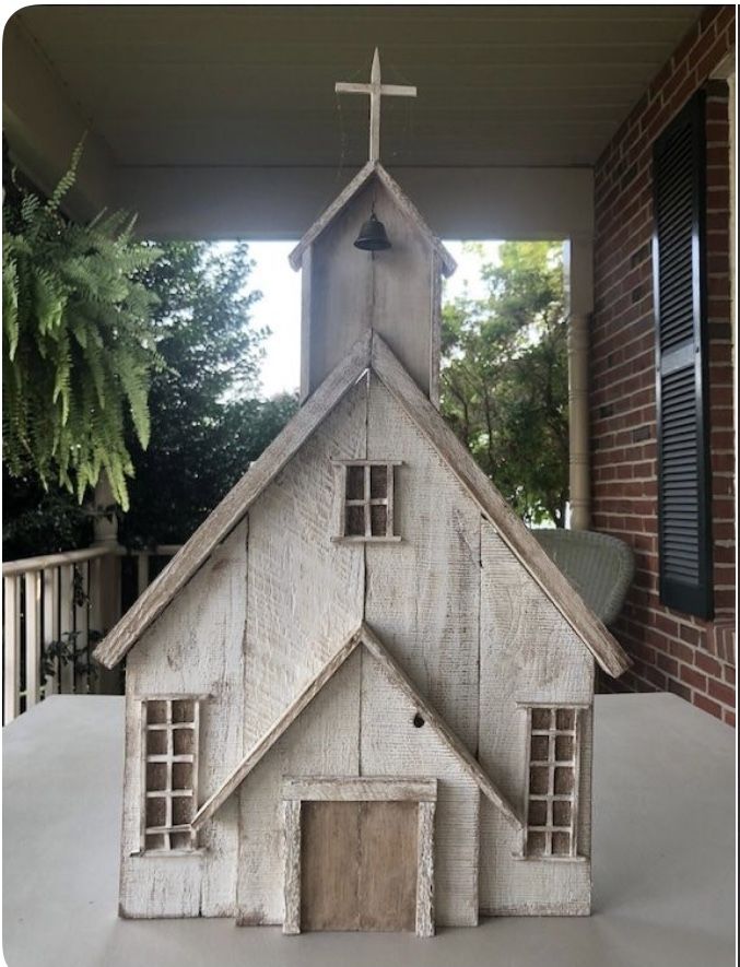 a small wooden church with a cross on top