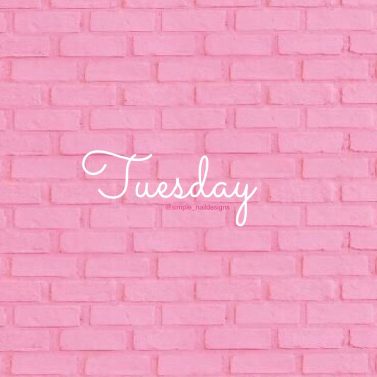 a pink brick wall with the word tuesday written on it in cursive font