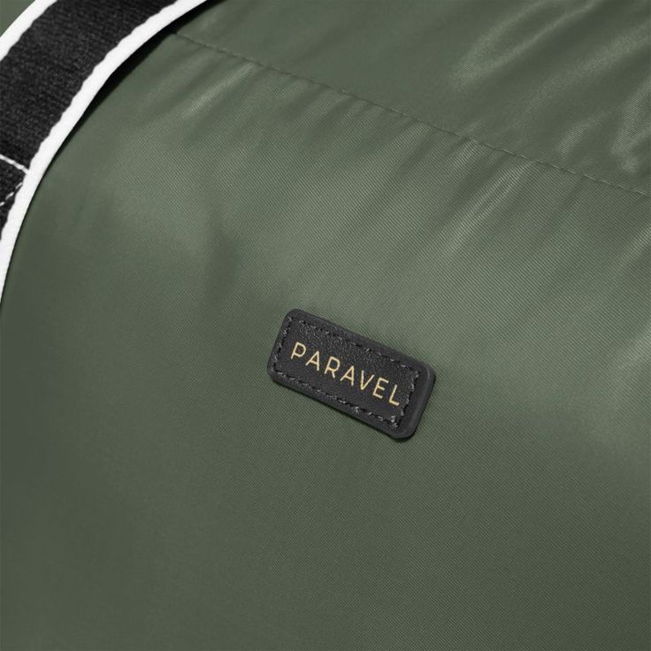 a close up view of the label on a green duffel bag with black and white stripes