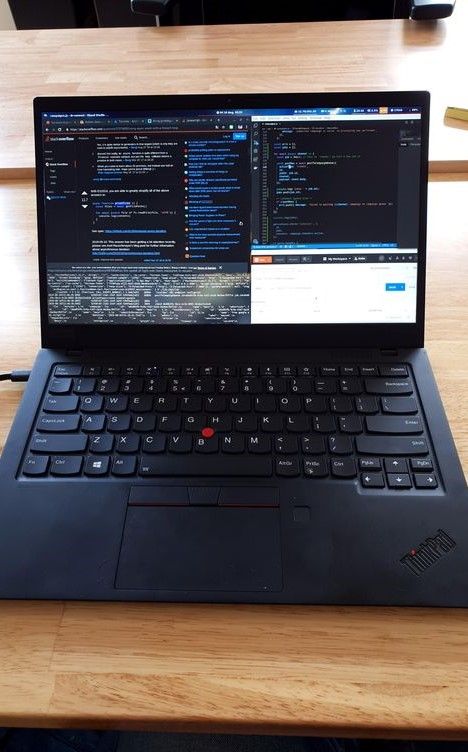 an open laptop computer sitting on top of a wooden desk